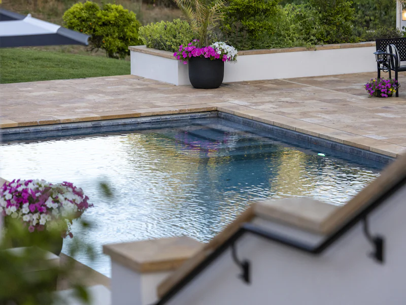 Piscina de una casa con jardín y flores